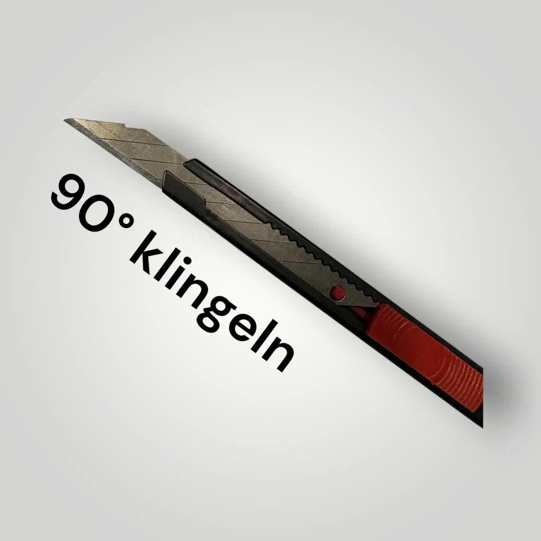 Schwarzes Allzweckmesser mit rotem Schieber und 90 Grad Klinge auf weißem Hintergrund