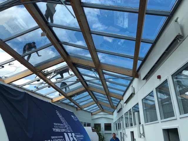 Mitarbeiter folieren ein Atriumdach