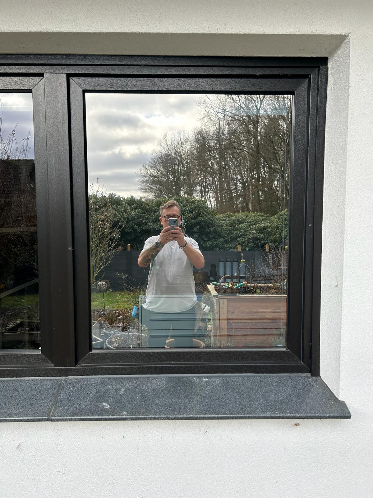 Reflektierende Fensterfolie silber, auf Außenfenster angebracht, spiegelt Umgebung