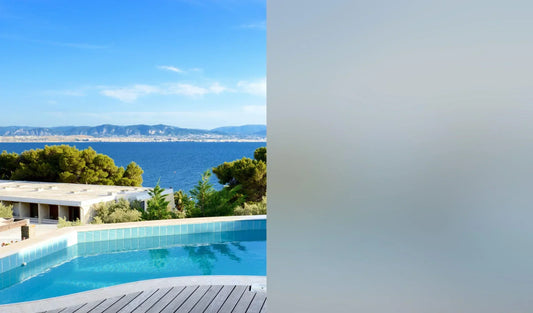 Mattgraue Fensterfolie zeigt Sichtschutz am Fenster mit Ausblick auf Pool, Meer und Berge