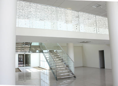Moderne Treppe mit Glasgeländer und dekorativer Fensterfolie für Sichtschutz in Bürogebäude