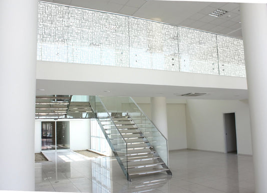 Moderne Treppe mit Glasgeländer und dekorativer Fensterfolie für Sichtschutz in Bürogebäude