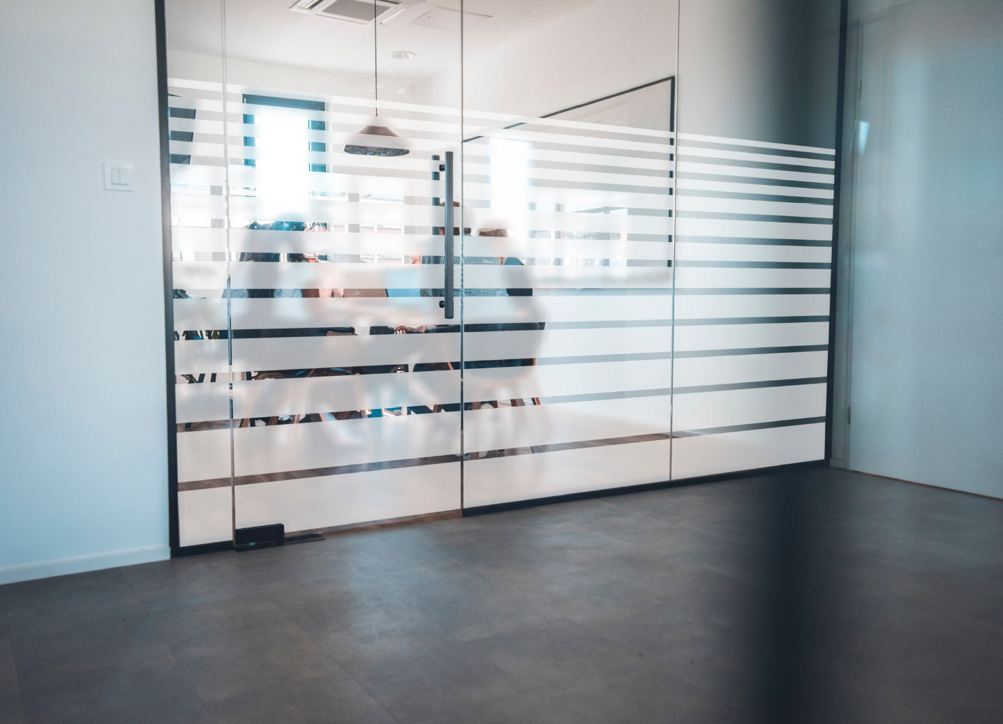 Glaswand mit Streifenfolie für Sichtschutz im Büro, ideal für Sonnenschutz und Privatsphäre