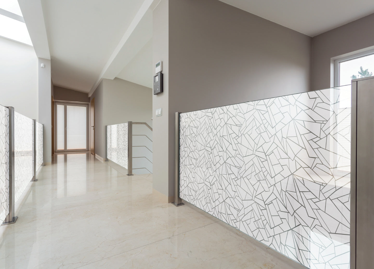 Moderne Glasgeländer mit geometrischer Sichtschutzfolie im Wohnhaus