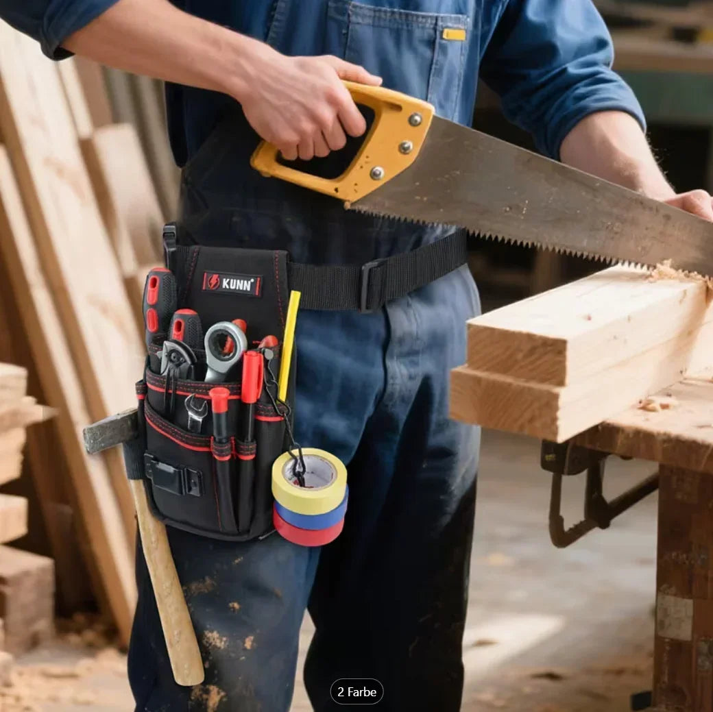 Handwerker im Blaumann mit Werkzeugtasche und Säge beim Arbeiten mit Holz in der Werkstatt