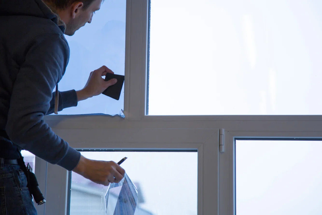 Ein Mann foliert ein Fenster
