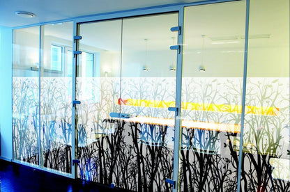 Glaswand mit dekorativer Fensterfolie in floralem Muster, ideal als Sichtschutz im Büro