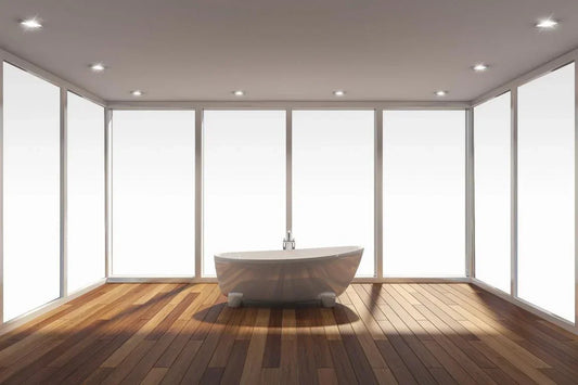 Moderne Badewanne vor großen Fenstern mit milchiger Fensterfolie, heller Holzfußboden