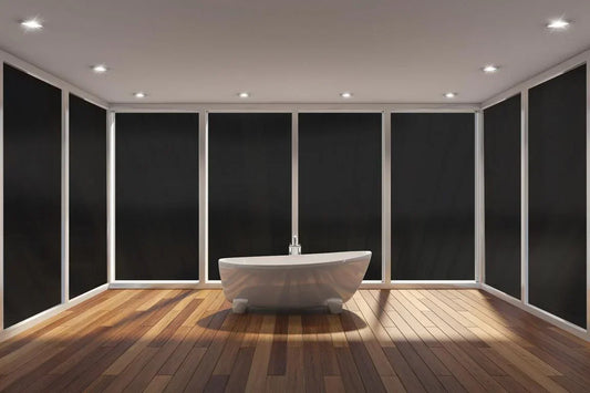 Badezimmer mit freistehender Badewanne und schwarzen, blickdichten Fensterfolien