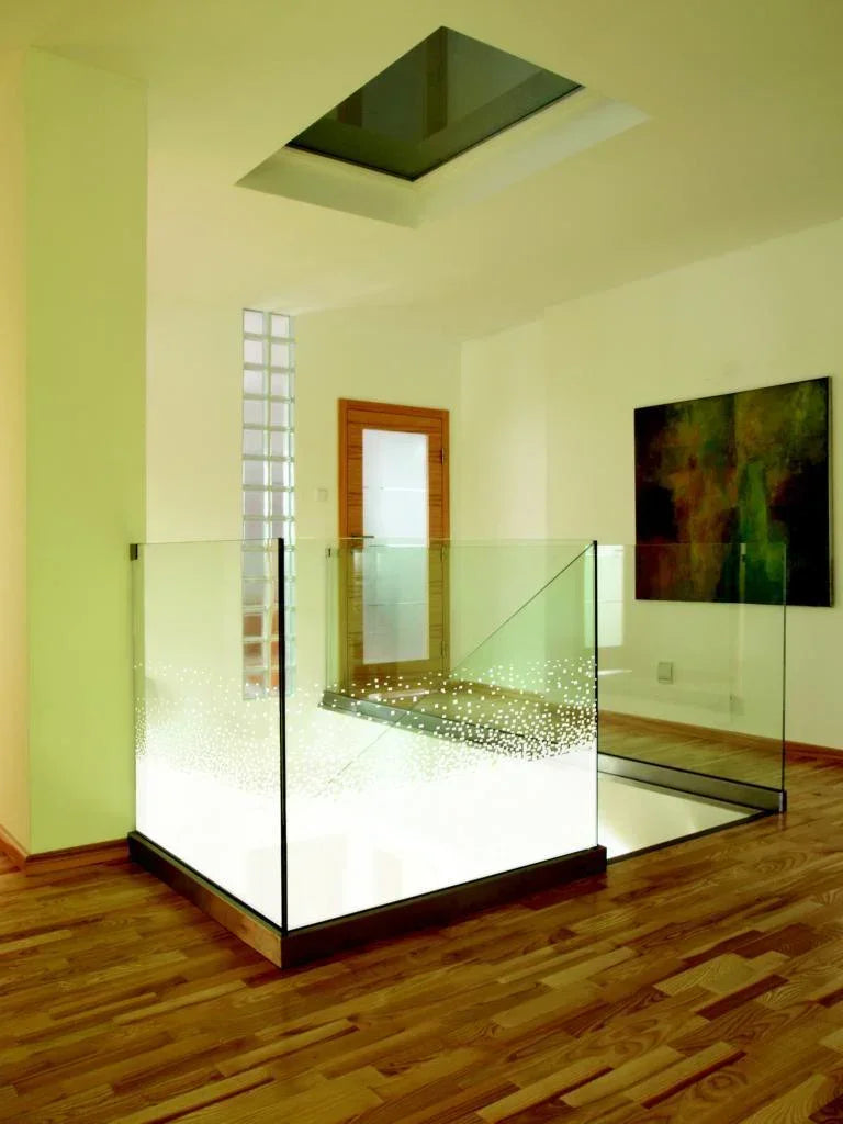 Moderne Glasgeländer mit dekorativer Fensterfolie in hellem Innenraum, Parkettboden, Kunst an Wand