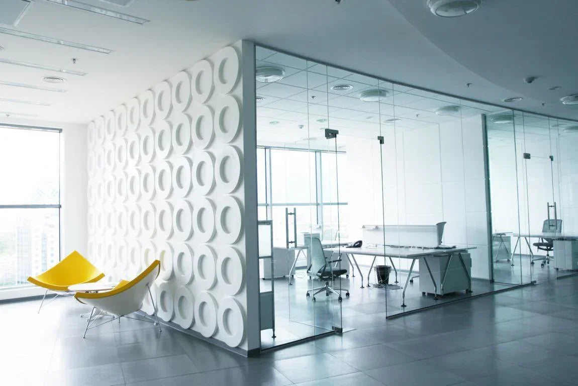 Modernes Büro mit Glastrennwänden, gelben Designstühlen und Fensterfront
