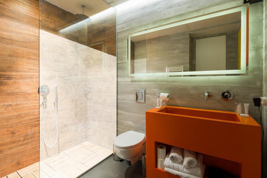 Modernes Badezimmer mit Holzoptik, Duschabtrennung mit Dekor-Fensterfolie, orange Waschtisch