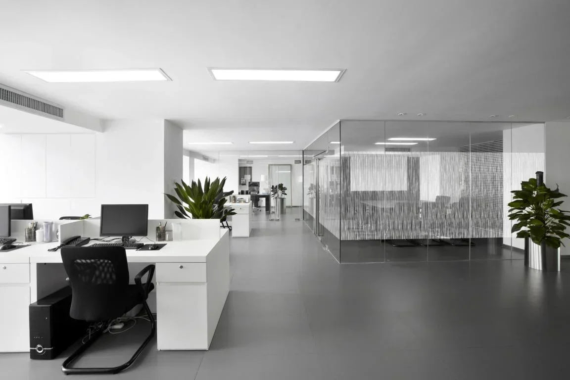 Modernes Büro mit Glaswand und dekorativer Fensterfolie mit Streifenmuster, helle Einrichtung