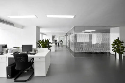 Modernes Büro mit Glaswand und dekorativer Fensterfolie mit Streifenmuster, helle Einrichtung